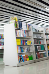 The aisles in a public library with shelves full of books