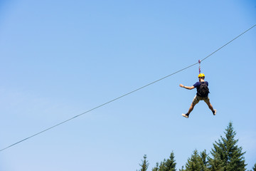 Young Man Riding On Zip Line