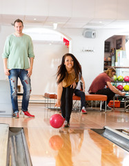 Obraz premium Happy Young Woman Bowling in Club