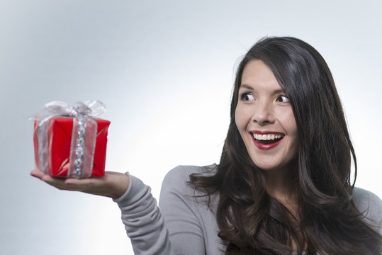 Beautiful woman looking at a gift in excitement