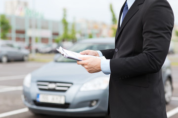 man with car documents outside