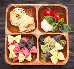 Italian pasta, farfalle, basil and tomatoes in a wooden box