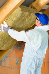 Handwerker schneidet Dämmmaterial