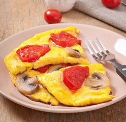Delicious omelet with tomatoes and mushrooms for breakfast