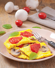 Delicious omelet with tomatoes and mushrooms for breakfast