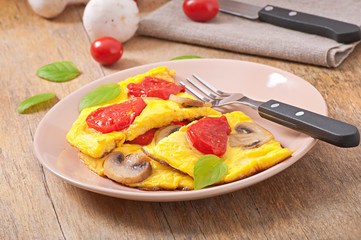 Delicious omelet with tomatoes and mushrooms for breakfast