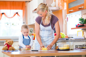 Mother and daughter baking cookies together