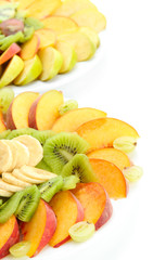 Fototapeta na wymiar Assortment of sliced fruits on plates, isolated on white