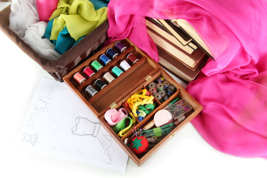 Sewing kit in wooden box with books and cloth isolated on white