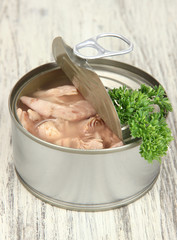 Open tin can, on wooden background