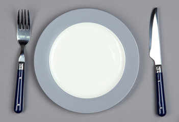 Knife, color plate and fork, on color background