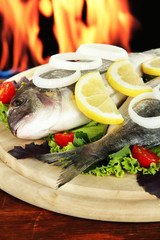Dorado fish on table on fire background