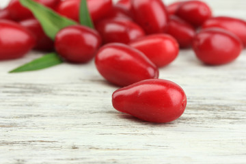 Fresh cornel berries on wooden background