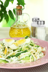 Delicious salad with eggs, cabbage and cucumbers on table