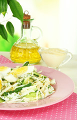 Delicious salad with eggs, cabbage and cucumbers on table