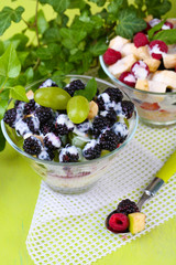Fruit salad in  glass bowls, on wooden background