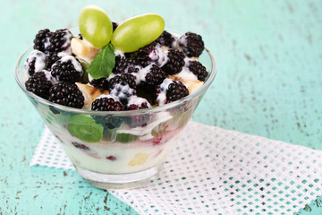 Fruit salad in  glass bowl, on wooden background