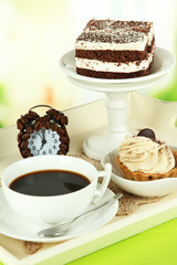Cup of tea with cakes on wooden tray on table in room