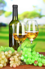 Naklejka na ściany i meble Ripe grapes, bottle and glasses of wine, on bright background