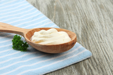 Fototapeta na wymiar Sour cream in spoon on table close-up