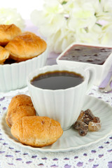 Tasty croissants and cup of coffee on table close-up