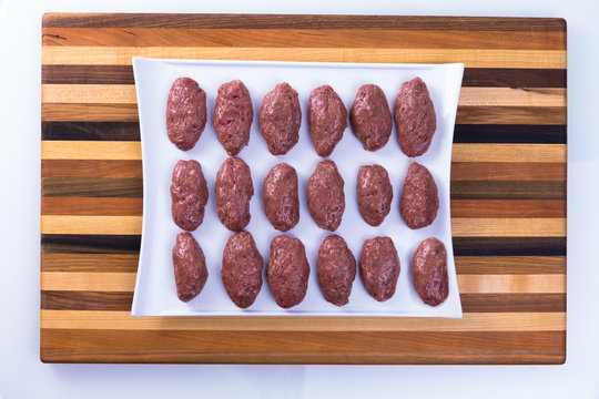 Prepped Ready to Cook Turkish Meat Balls on a wooden Board
