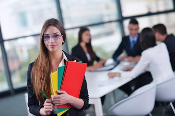 business woman with her staff in background at office