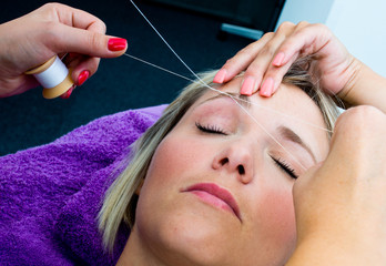 Fototapeta premium threading hair removal procedure