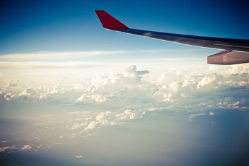 Fototapeta premium Clouds and sky as seen through window of an aircraft at sunset