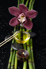 red orchid and bamboo grove,massage oil,stone on wet black