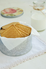 Crumbly cookies in tin box on vintage doily