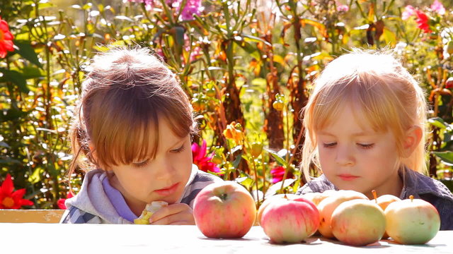 две девочки с яблоками, едят разговаривают