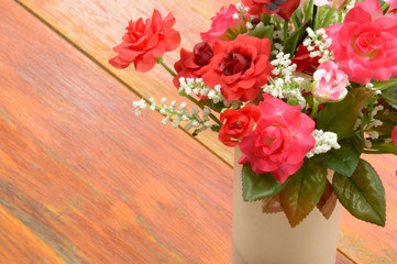 bouquet red and pink rose in white vase on wood floor