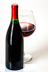 Wine bottle and a glass filled with wine isolated on white