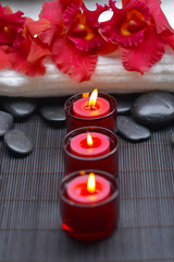 candle with red orchid with towel, stones at spa