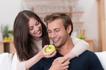 mädchen hält ihrem freund einen apfel vor die nase