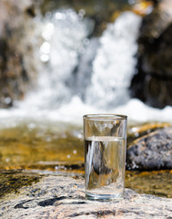 Glass of water by waterfall