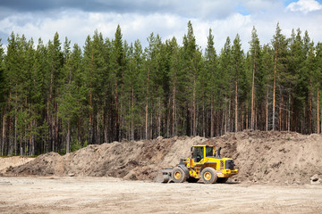 Yellow excavator in sandpit