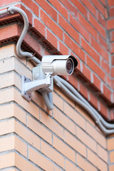 Video surveillance camera on brick wall