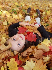 Autumn fun - lovely girl playing in autumn park
