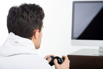 Gamer. Rear view of young man playing video games while isolated