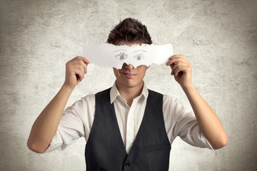 Young man with eyes paper