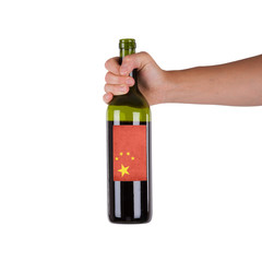 Hand holding a bottle of red wine