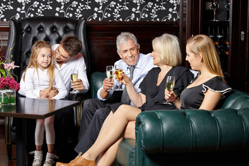 Familie beim Sektempfang im Wohnzimmer