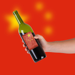 Hand holding a bottle of red wine