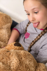 Cute girl with toy bear. Cheerful little girl holding toy bear a