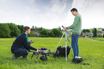 Engineers Working On UAV Helicopter in Park