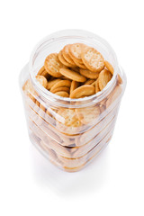 Jar of small appetizer crackers isolated on white.