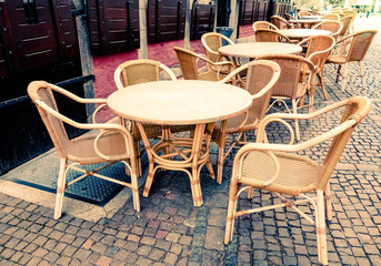 Street view of a coffee terrace with tables and chairs