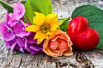 Sonnenblume, Hortensie und Rose mit Herz auf Holz